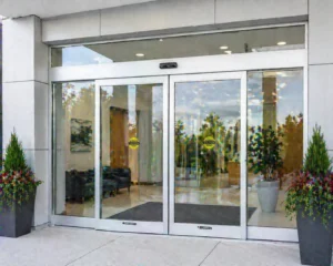 Automatic sliding doors with a directory board beside it.